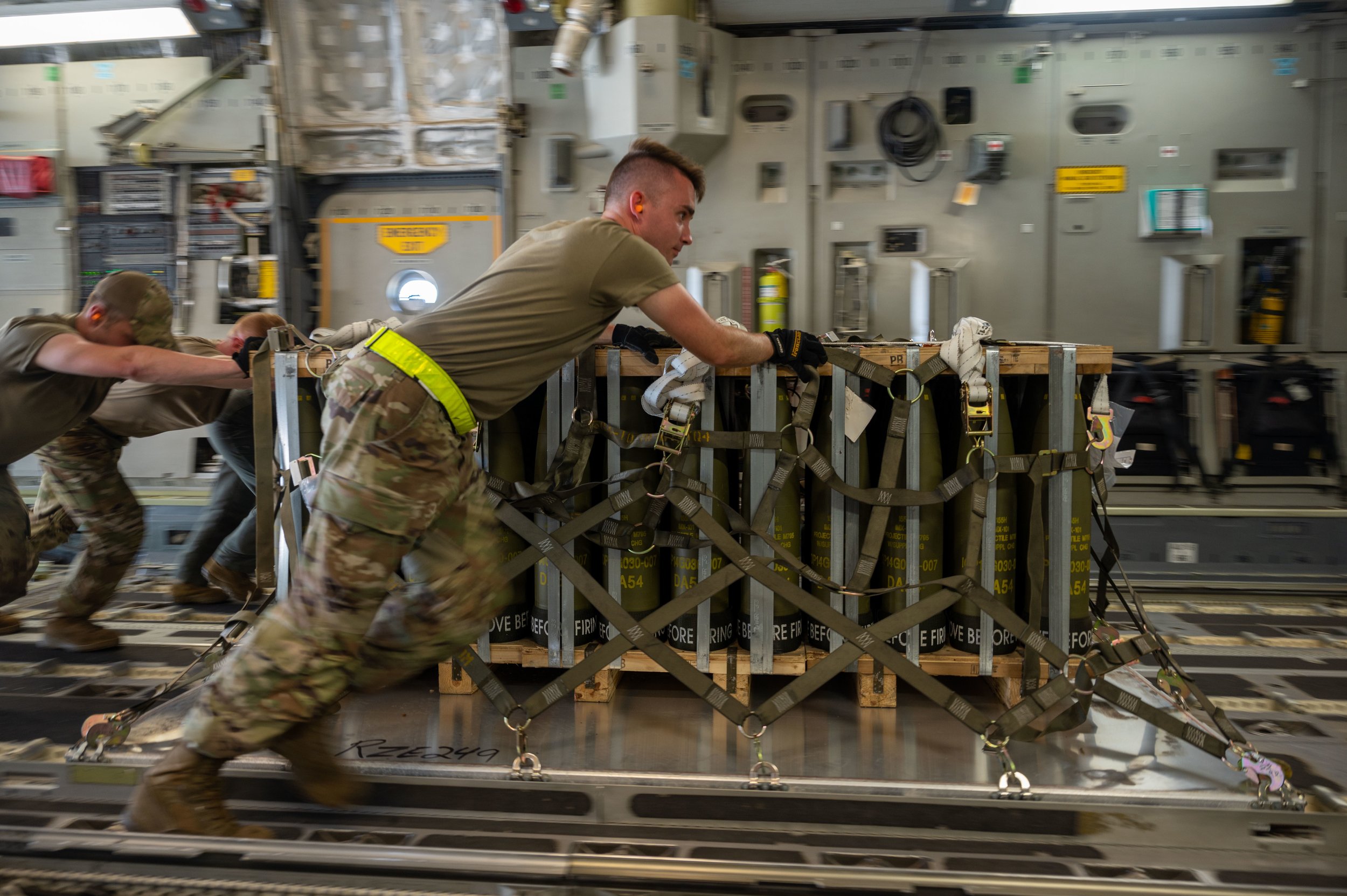 United States Airmen load supplies onto an airplane.