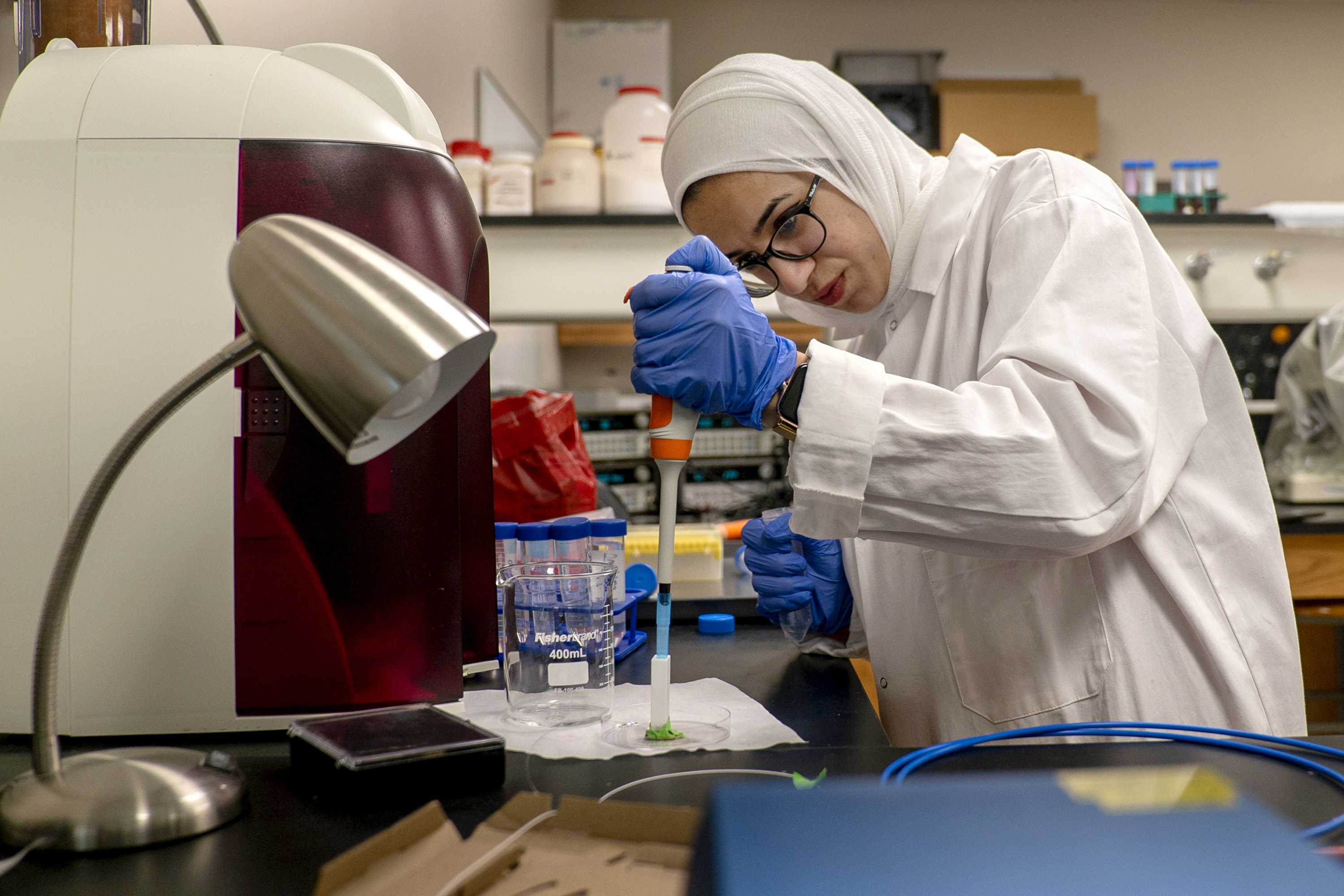 Mai Abuhelwa injects a chicken sample into a prototype salmonella sensor.